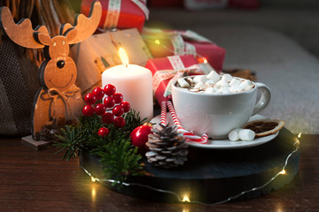 Christmas interior with a Cup of Coffee on the sofa, gift boxes, garlands and Christmas composition