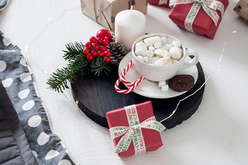 Christmas Breakfast in bed with a Cup of Coffee gift boxes, garlands and Christmas composition.