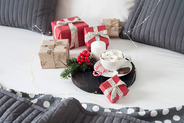 Christmas Breakfast in bed with a Cup of Coffee gift boxes, garlands and Christmas composition.