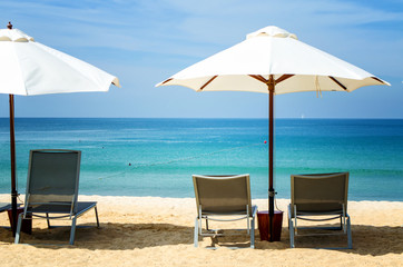 White umbrella and deckchair on the beach