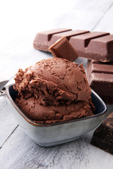 chocolate ice cream scoops with pieces of chocolate on wooden background