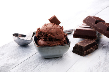 chocolate ice cream scoops with pieces of chocolate on wooden background