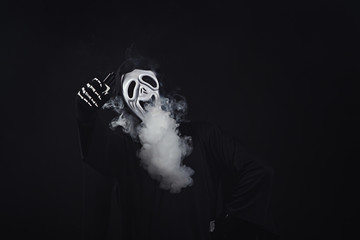 man in a terrible mask and black cloak vape