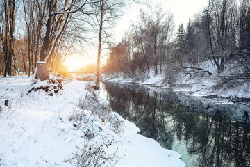 Winter landscape by a river in the sunset
