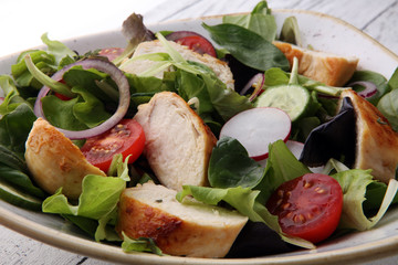 Chicken salad with leaf vegetables and cherry tomatoes.