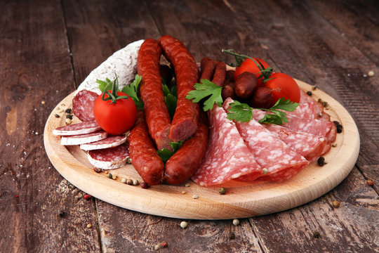 Food tray with delicious salami, pieces of sliced ham, sausage, tomatoes, salad and vegetable - Meat platter with selection - Cutting sausage and cured meat