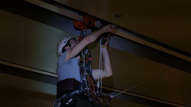 Industrial climber mounts Christmas decorations in the unsupported space in the shopping center