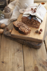 Cake loaf with nuts and chocolate on a wooden board
