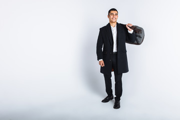 Stylish man in Studio on a white background, with a bag for travel, isolated, background, man goes on a journey