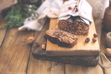 Cake loaf with nuts and chocolate on a wooden board