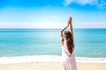 Beautiful young single white woman on beach. Standing happy freedom pose relaxing, wearing white...