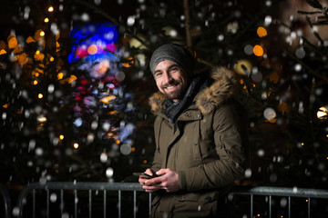 Cheerful Man Dressed Warm at Christmas Tree