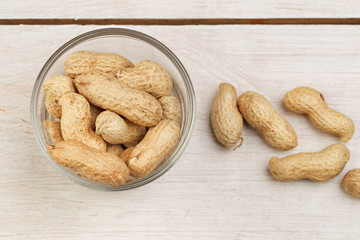crude peanuts on the wooden background