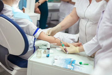 The doctor takes blood from veins