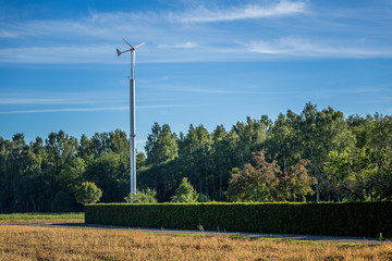 Fototapeta premium Electric windmill in countryside forests.