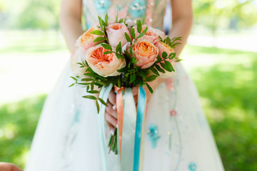 Wedding bouquet, Bridal bouquet, the bride holding a bouquet, the bride in a wedding dress, the bride's bouquet of pink peonies decorated with ribbons