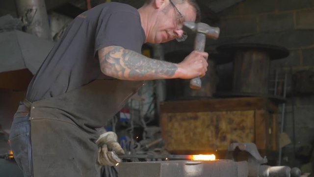 Master blacksmith working on his art, sparks flying