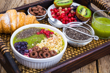 Wooden tray with fruit dishes and croissant for lunch