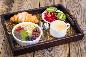Wooden tray with fruit dishes and croissant for lunch