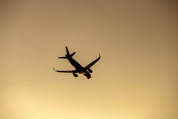 Airplane take off silhouette with sunlight in background.