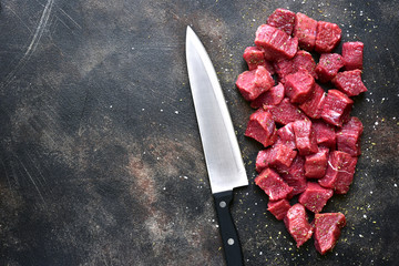 Cut beef on a dark metal or slate background.Top view with copy spqace.