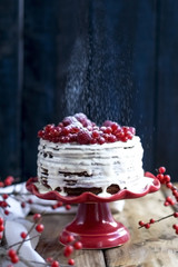 white cake with red berries on a black background