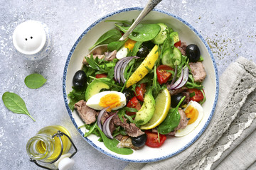 Tuna salad with mix salad leaves (spinach and arugula) , avocado, cherry tomato, cucumber and egg.Top view.