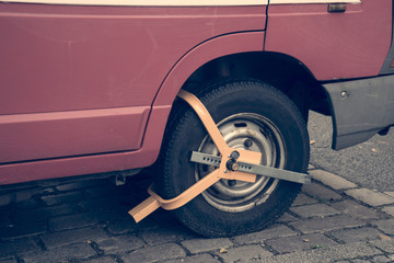 Cepo metálico con candado en rueda de coche.