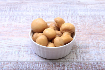 Marinated champignons in white bowl. ready for cooking.
