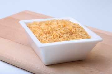 Rice in a bowl on wooden background. ready for cooking.