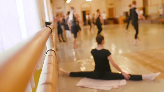 The ballet troupe rehearses in a ballet class against the backdrop of a ballet or barre