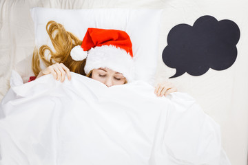 Sleeping woman wearing pajamas and Santa Claus hat