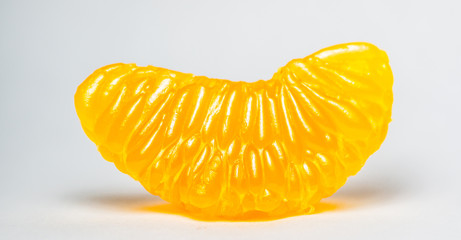Grains of peeled orange taken by macro photography. A single orange peeled with white background also called pulp orange.