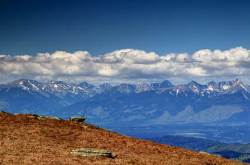 Peaks of Western Tatras with snow patches under layer of cumulus clouds in a sunny spring day, Baranec, Jakubina and Bystra, Zapadne Tatry, Liptov region, from Kralova Hola Low Tatras Slovakia Europe