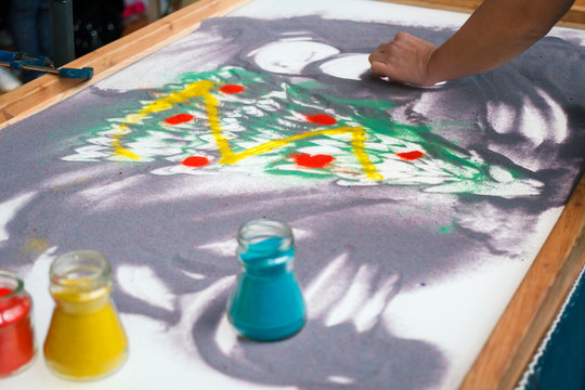 Sand animation, drawing sand closeup, girl draws a Christmas tree on the sand.