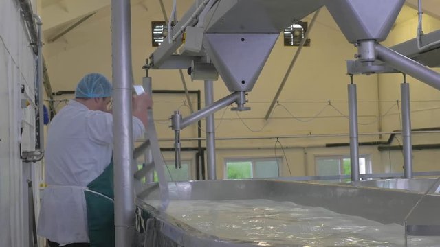 Man changing whisk on cheese making vat for cleaning