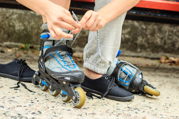 Woman putting on roller skates outdoor.