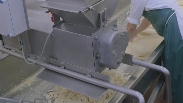Man doing labour intensive work in cheese making factory
