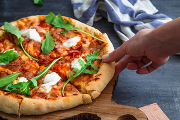 People Hands Taking Slices Of Pizza Margherita. Black background.