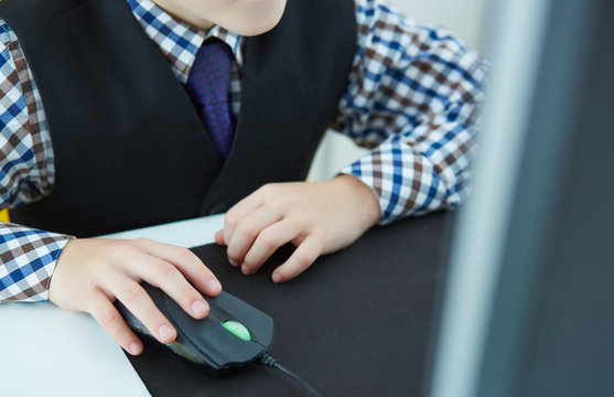 Close-up image of a hand of a little boy working at a computer.