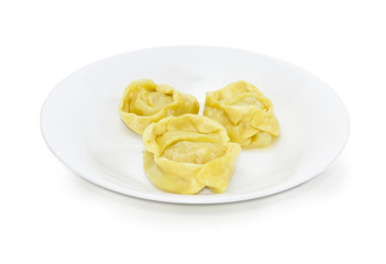 Three boiled manti on the white dish on a white background