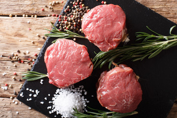 fresh raw beef filet mignon with spices cut ready to cook close up. horizontal top view