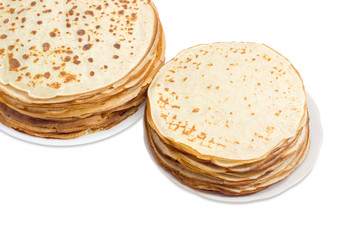 Thin round pancakes on two white dishes