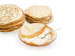 Thin pancake during rolling up with cottage cheese filling