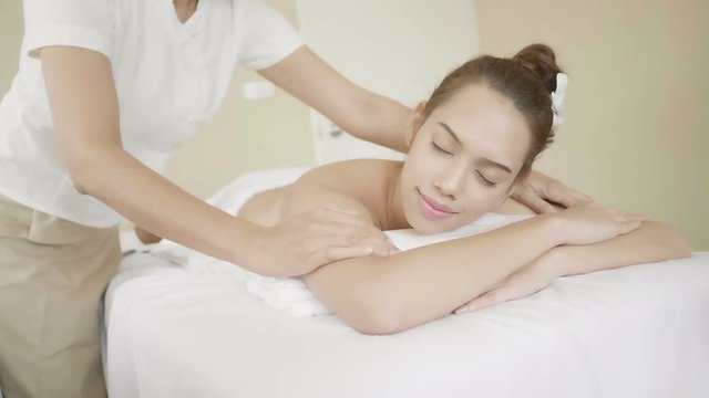 
Relaxed young woman lying down on massage bed during facial treatment at spa and wellness center