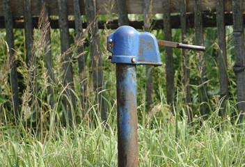 Water pump against a blockhouse in the village