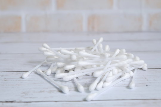 Selective focus of white cotton buds or cotton swab on wooden background.