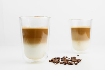 Two Hot Coffee Drinks With Milk With Coffee Beans On White Background