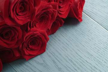 red roses on light blue wood background
