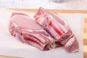 Raw pork chops, spices on cutting board. Ready for cooking.